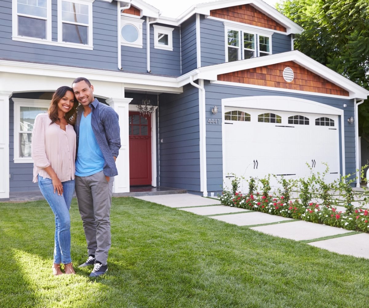 happy buyers in front of home